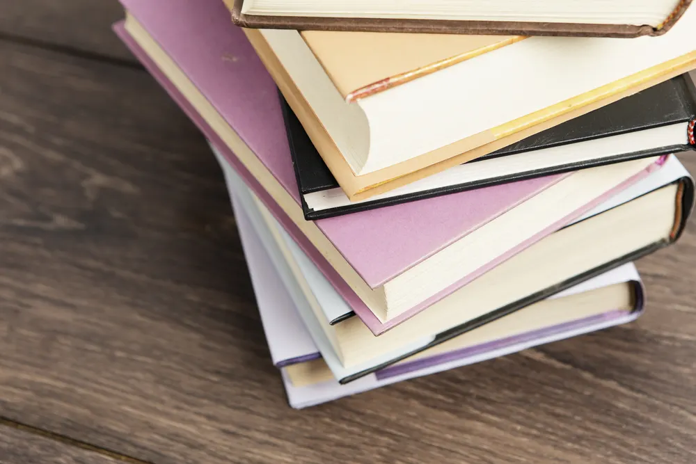 Stapel gebundener Bücher auf einem Holztisch
