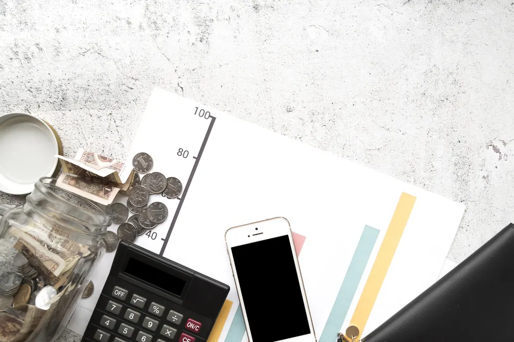 Taschenrechner, Smartphone und Notizen auf einem Schreibtisch