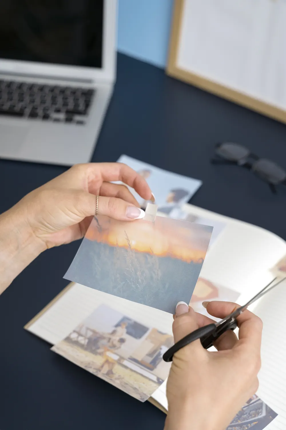 Hände halten einen Fotoabzug über weiteren Bildern
